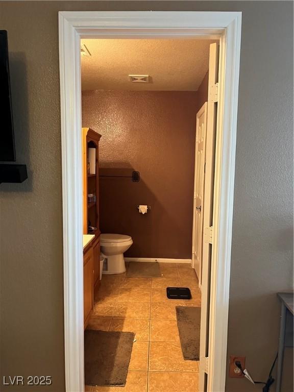 bathroom with toilet, tile patterned floors, and vanity