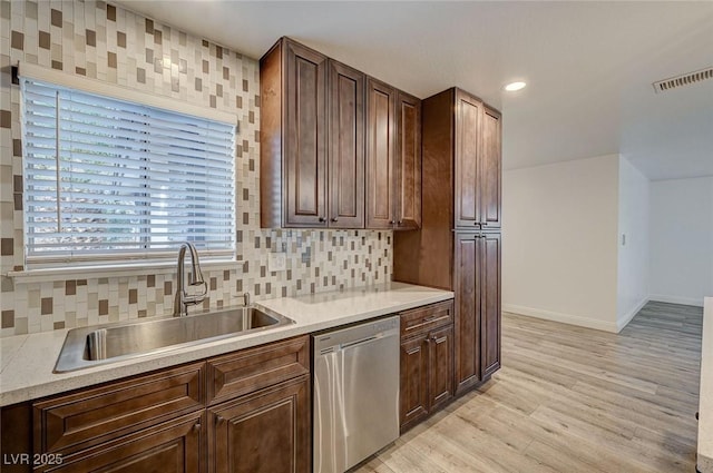 kitchen with sink, stainless steel dishwasher, tasteful backsplash, dark brown cabinets, and light hardwood / wood-style floors