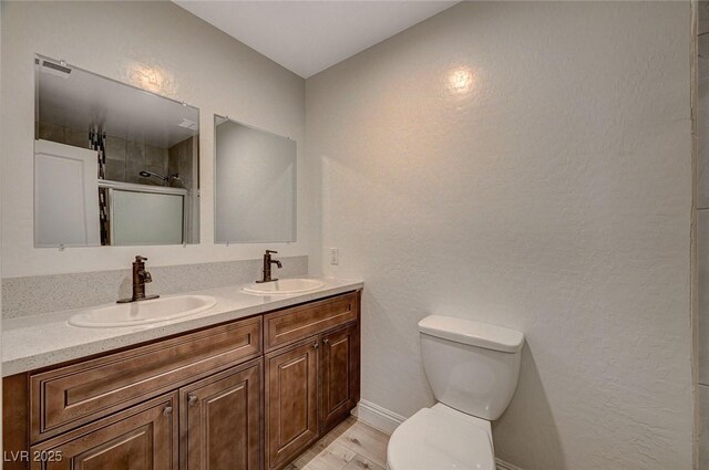 bathroom featuring vanity, toilet, and an enclosed shower