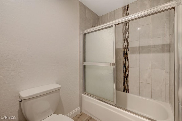 bathroom featuring shower / bath combination with glass door, wood-type flooring, and toilet