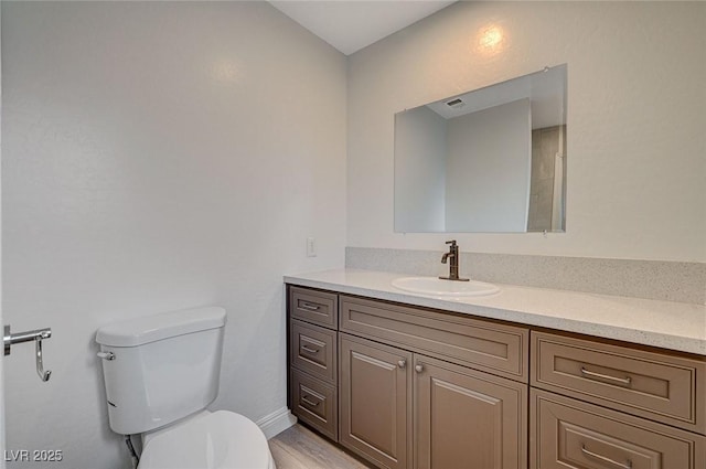 bathroom featuring hardwood / wood-style floors, vanity, and toilet