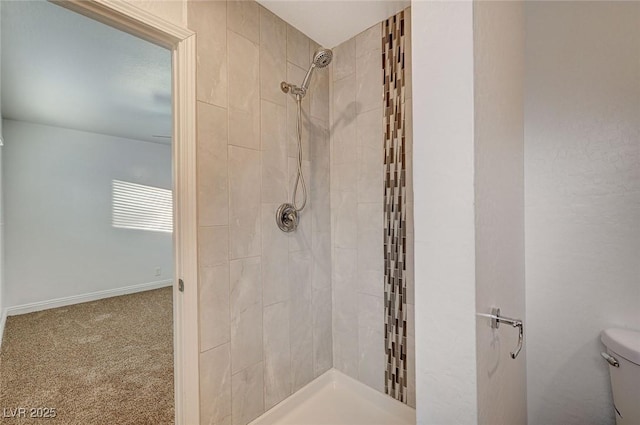 bathroom featuring tiled shower and toilet