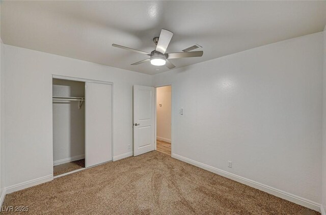 unfurnished bedroom featuring carpet, ceiling fan, and a closet