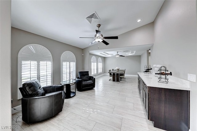 living room featuring ceiling fan and lofted ceiling