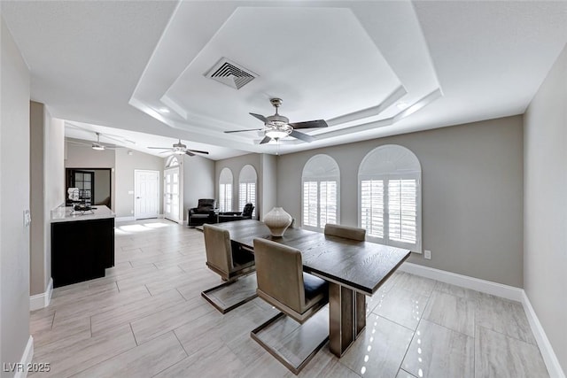 dining area with a tray ceiling and a healthy amount of sunlight