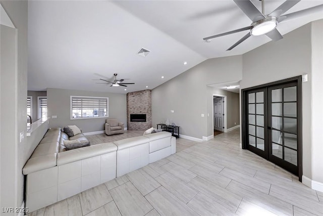 living room with a fireplace, french doors, ceiling fan, and lofted ceiling