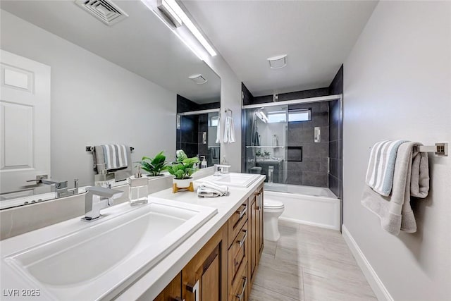 full bathroom with vanity, toilet, and bath / shower combo with glass door