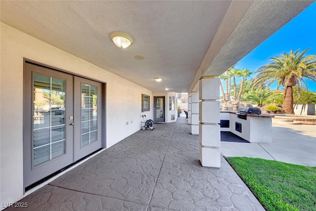 view of patio with french doors, area for grilling, and a grill