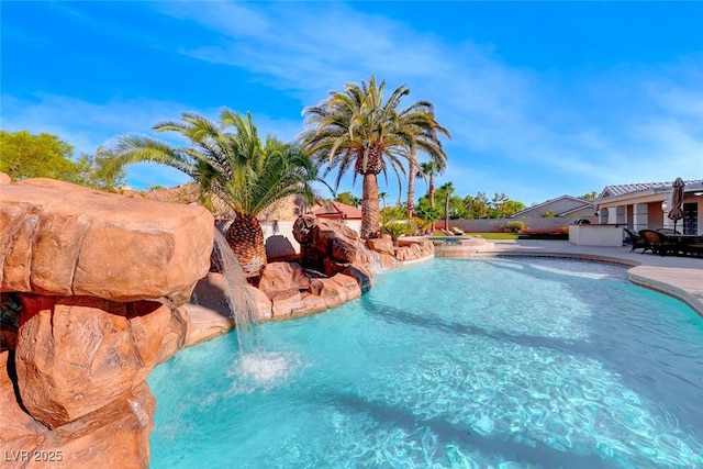 view of swimming pool featuring pool water feature and a jacuzzi