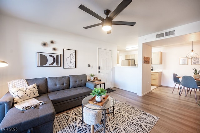 living room with light hardwood / wood-style floors and ceiling fan