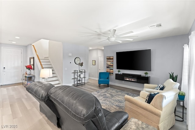 living room with ceiling fan and light hardwood / wood-style flooring