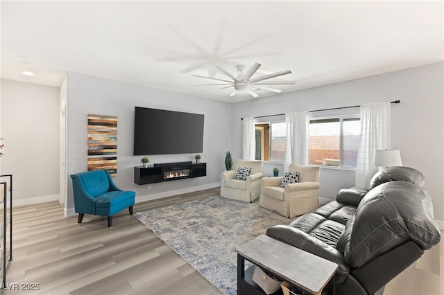 living room with light hardwood / wood-style flooring and ceiling fan