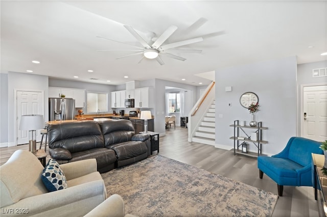 living room featuring ceiling fan, light hardwood / wood-style floors, and sink