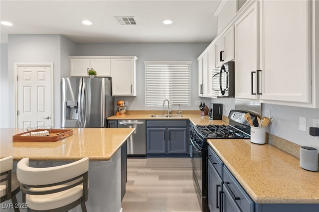 kitchen featuring light stone counters, sink, white cabinetry, and stainless steel appliances