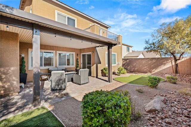 back of property with outdoor lounge area and a patio