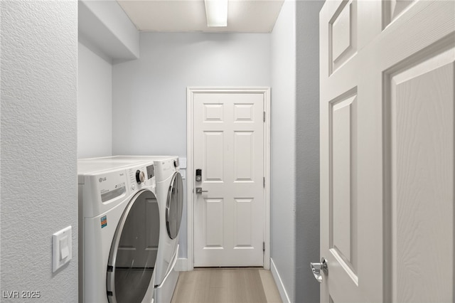 washroom featuring washer and clothes dryer and light hardwood / wood-style floors