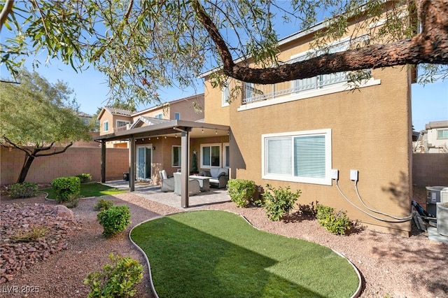 rear view of house with an outdoor living space and a patio area