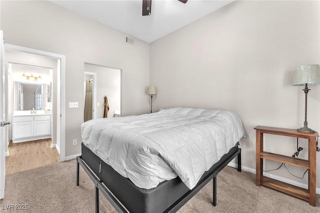 bedroom featuring connected bathroom, ceiling fan, and light colored carpet