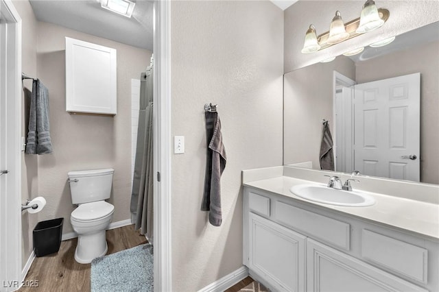 bathroom featuring curtained shower, toilet, vanity, and hardwood / wood-style flooring