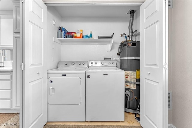 laundry room featuring secured water heater and independent washer and dryer