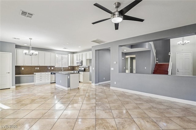 kitchen featuring white cabinets, decorative light fixtures, light tile patterned floors, and appliances with stainless steel finishes