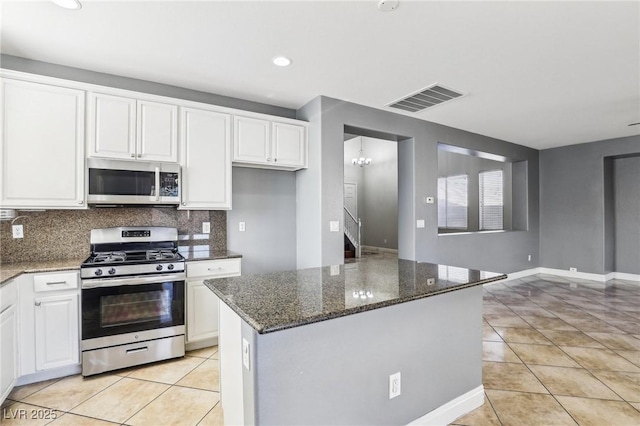 kitchen featuring white cabinets, appliances with stainless steel finishes, a center island, and light tile patterned floors