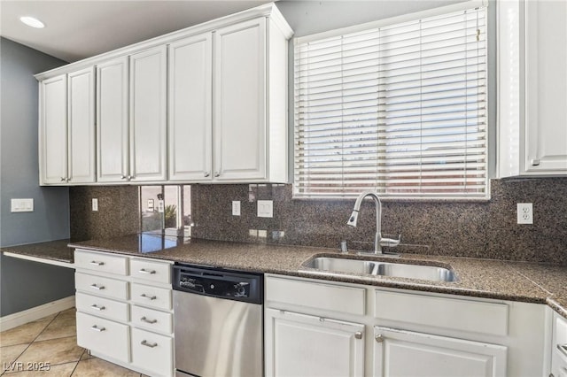 kitchen with sink, stainless steel dishwasher, light tile patterned floors, tasteful backsplash, and white cabinetry