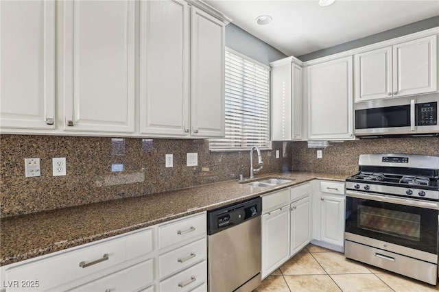 kitchen with light tile patterned flooring, white cabinetry, sink, and appliances with stainless steel finishes