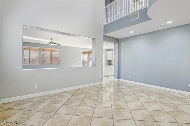 tiled empty room featuring ceiling fan