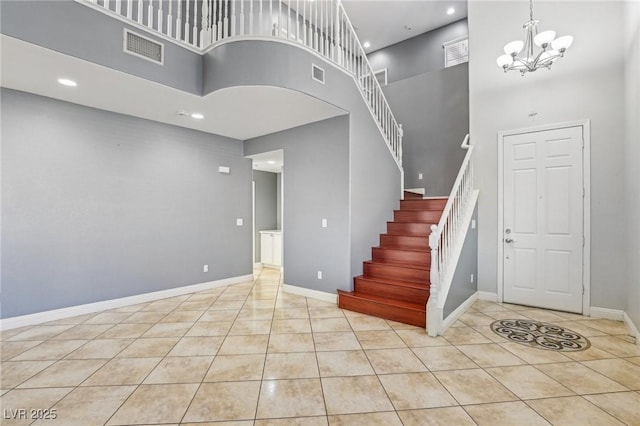 stairway featuring tile patterned flooring, a high ceiling, and a notable chandelier