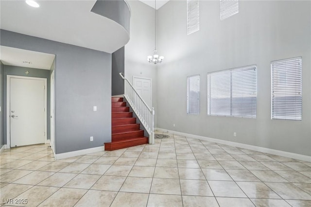 interior space featuring light tile patterned floors, an inviting chandelier, and a high ceiling