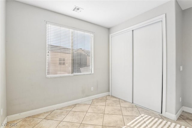 unfurnished bedroom with light tile patterned floors and a closet