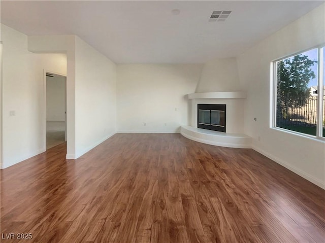 unfurnished living room with a fireplace and dark wood-type flooring