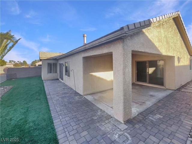 rear view of house featuring a patio area and a lawn