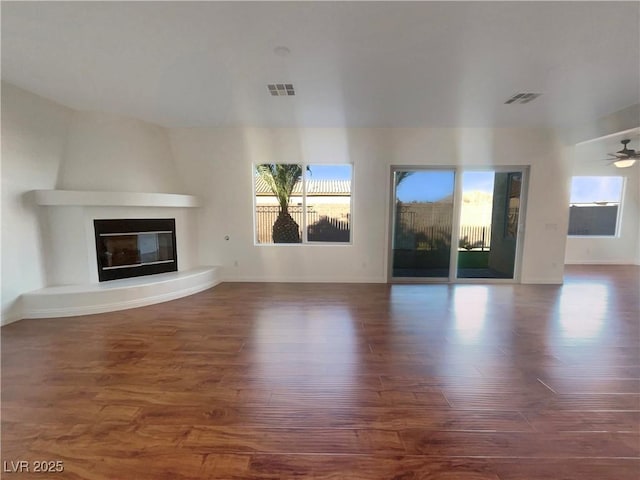 unfurnished living room with ceiling fan and dark wood-type flooring