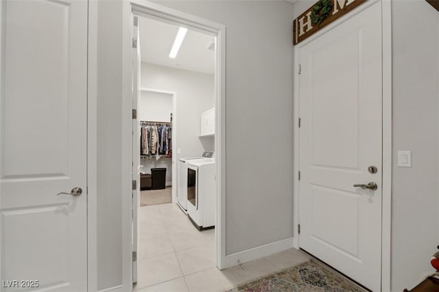 corridor with washer and dryer and light tile patterned floors