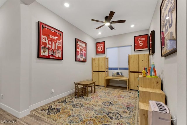 living area featuring hardwood / wood-style floors and ceiling fan