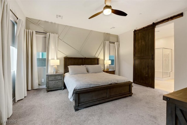 carpeted bedroom with a barn door and ceiling fan