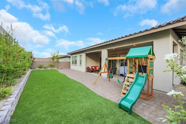 view of playground featuring a patio area and a yard