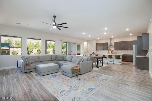 living room featuring ceiling fan and light wood-type flooring