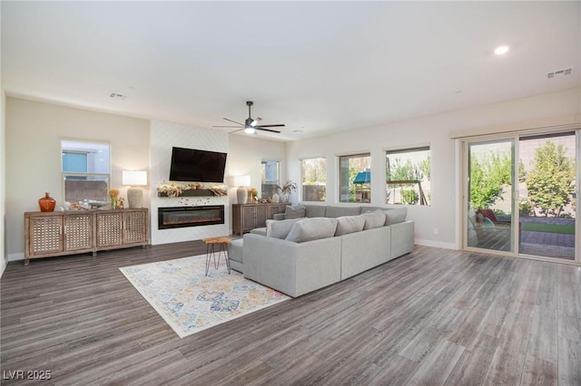 living room featuring a fireplace, dark hardwood / wood-style floors, and ceiling fan