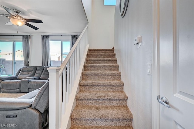 staircase featuring ceiling fan