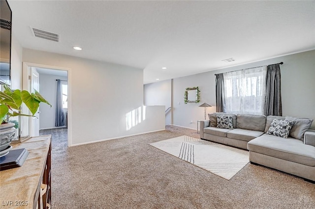 carpeted living room featuring plenty of natural light, visible vents, baseboards, and recessed lighting