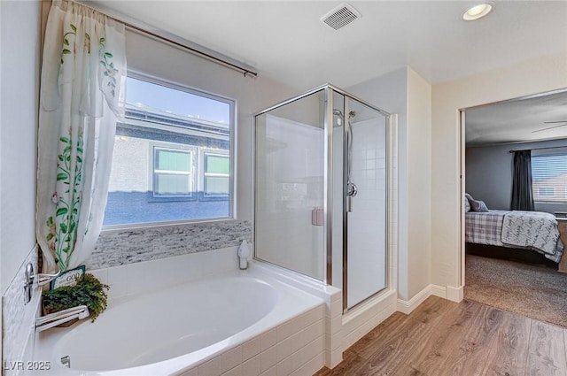 ensuite bathroom with a stall shower, visible vents, wood finished floors, ensuite bathroom, and a garden tub