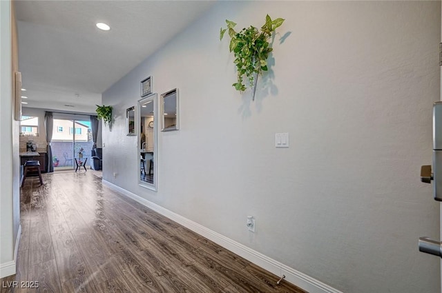 hallway featuring baseboards and wood finished floors