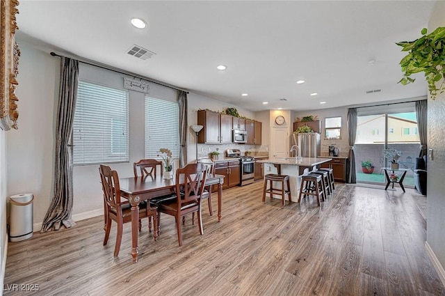 dining space with light wood finished floors, baseboards, visible vents, and recessed lighting