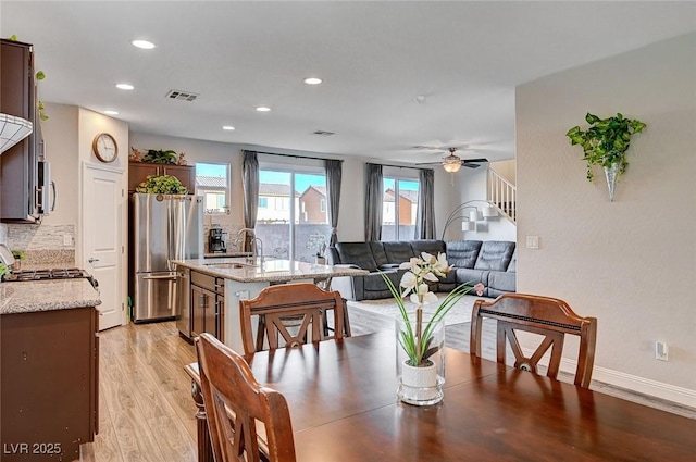 dining room with visible vents, baseboards, light wood-style flooring, ceiling fan, and recessed lighting