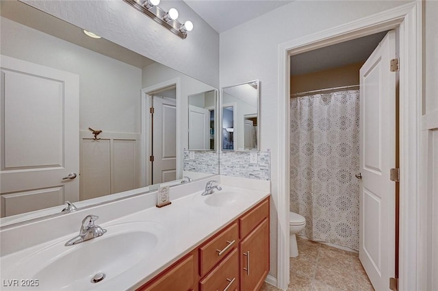 bathroom with toilet, curtained shower, double vanity, and a sink