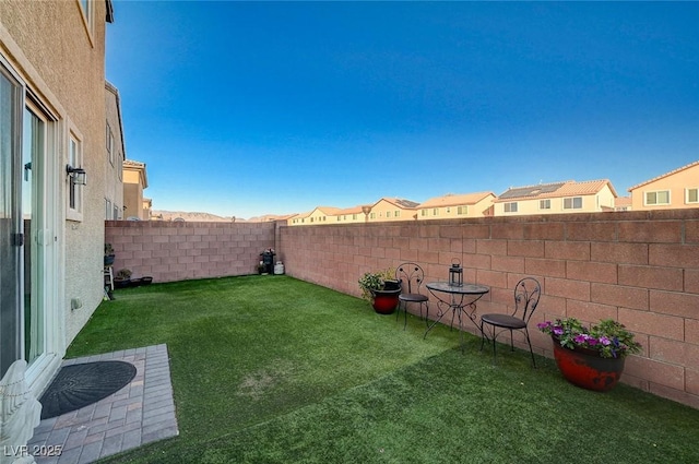 view of yard with a fenced backyard and a residential view