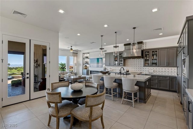 tiled dining space featuring french doors, ceiling fan, and a healthy amount of sunlight